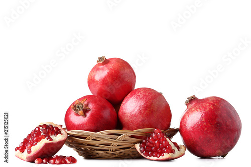 Ripe and juicy pomegranate in basket on white background