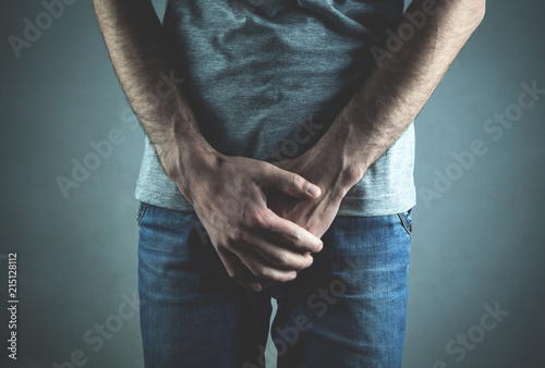 Caucasian man with hands holding his crotch. Inflammation of the prostate, erection problems