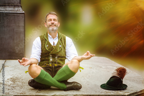 bavarian man sitting on wall and meditating