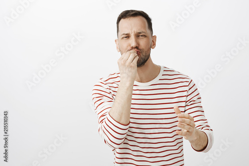 Husband preparing dinner for loving wife. Portrait of joyful handsome mature male with beard, kissing fingers while making delicious gesture, cooking meal and being passionate with food