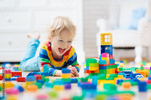 Child playing with toy blocks. Toys for kids.