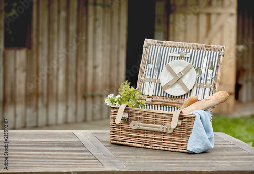 Open fitted wicker picnic hamper on a garden table