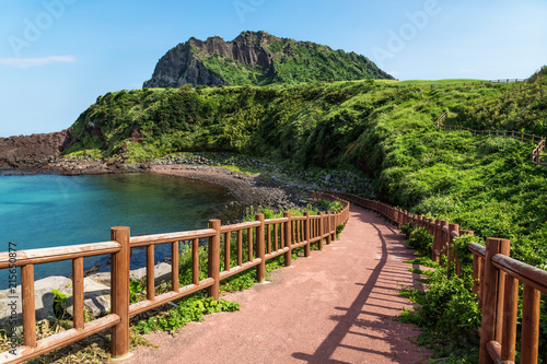 Pathway leading to beach with view over ocean and Ilchulbong, Seongsan, Jeju Island, South Korea