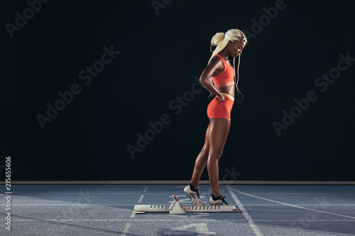Woman runner standing on a running track