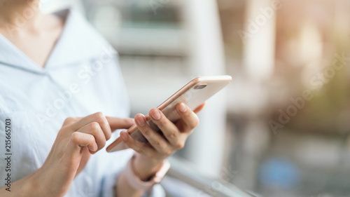 woman using smartphone on staircase in public areas, During leisure time. The concept of using the phone is essential in everyday life.