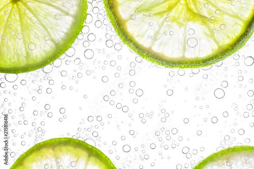 close up fresh lime sliced in soda or water bubbles, isolated on white background
