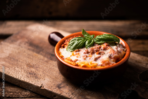 Traditional lasagne in a casserole dish on wooden table