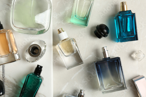 Perfume bottles on light background, flat lay