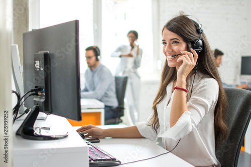 Friendly female customer service helpline operator working on computer in ofice 