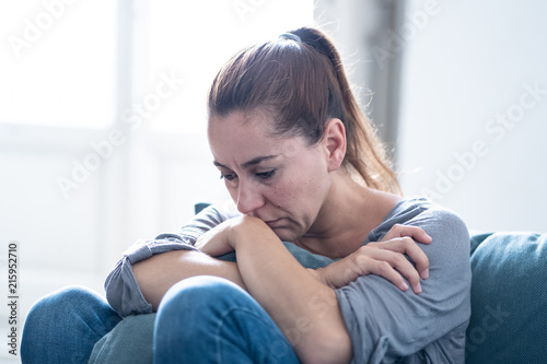 Young attractive latin woman lying at home living room couch feeling sad tired and worried suffering depression in mental health, problems and broken heart concept.