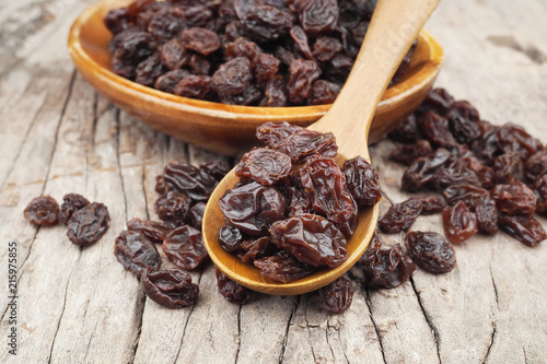 Organic dried Raisins in wood spoon on wooden table, Currant