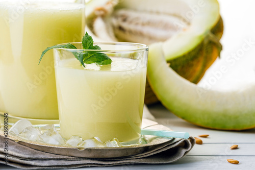 melon smoothie in glass and bottle on white background, summer drink, cocktail