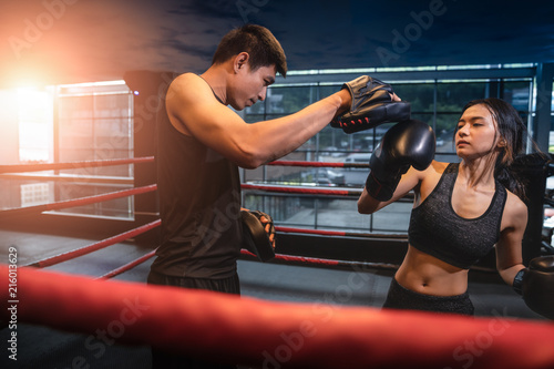 Young adult woman doing kickboxing training with her coach.