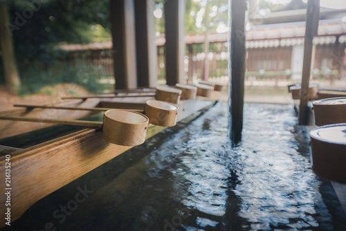 Wooden dipper of holy zen water at the entrance of a shrine in Japan. Vintage tone