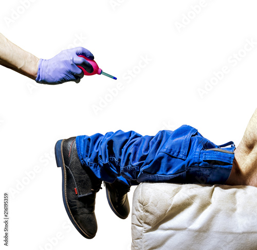 Hand in Glove holds pear-shaped enema in front of man's leg with his trousers down on his knees on the couch