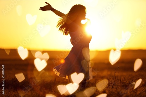 Young woman on field under sunset light