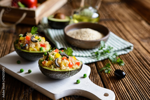 Avocado stuffed with quinoa, green peas, tomato, olives, bell pepper and parsley