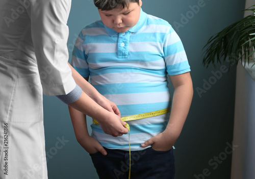 Doctor measuring overweight boy in clinic