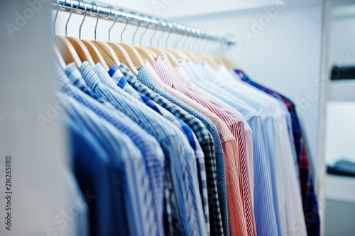 Close-up photo of fashionable clothes on hangers in the shop.