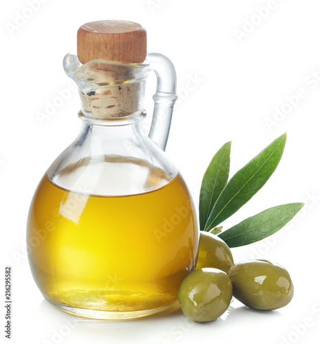 Bottle of olive oil and green olives with leaves