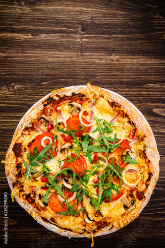 Pizza with ham and vegetables on wooden table 