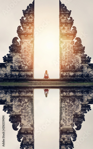 Woman sitting on the Gate of Temple , Bali, Indonesia. Calm, relax ,mind reset concept.