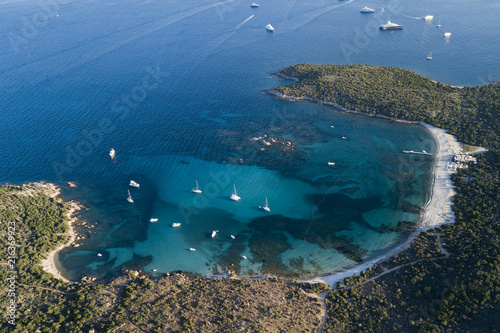 View from above, aerial view of an emerald and transparent Mediterranean sea with a white beach and some boats and yachts. Costa Smeralda, Sardinia, Italy