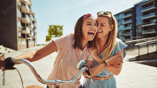Laughing female friends having fun walking together through the