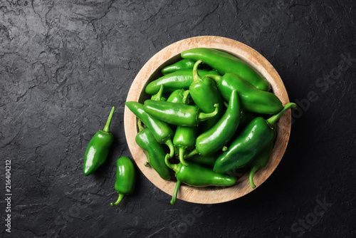 Green jalapeno hot pepper in wooden plate closeup. Food photography