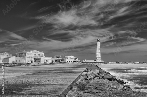 Portugalia, wyspa Farol. Falochron, biała latarnia morska.