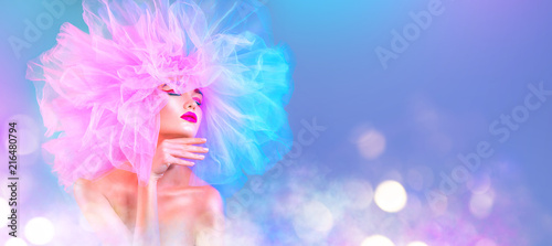 Fashion model woman in colorful bright lights posing, portrait of beautiful sexy girl with trendy makeup and colorful pink hairdo. Art design