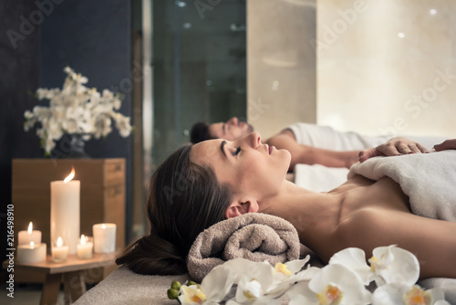 Young man and woman lying down on massage beds at Asian luxury spa and wellness center