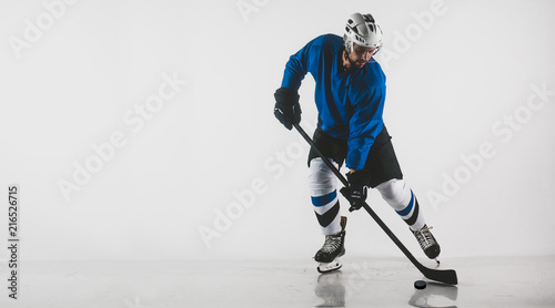 Portrait of Caucasian male ice hockey player in uniform performing a wrist shot against white background