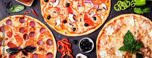 selection of different pizzas on a black background and ingredients. Peperoni, Vegetarian and Seafood Pizza
