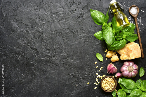 Ingredients for making traditional italian sauce pesto : basil leaves, parmesan cheese, olive oil, garlic, pine nuts and sea salt. Top view with copy space.