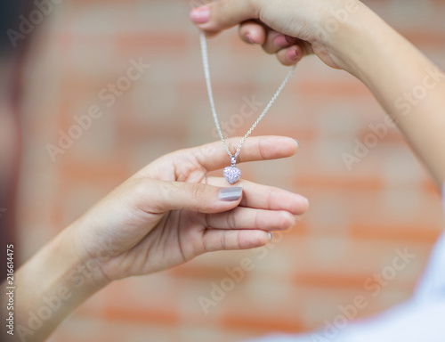 Woman holding necklace and pendant