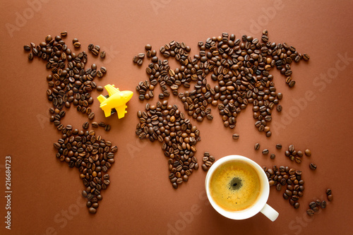 Map of the world made of roasted arabica coffee beans on brown paper background. International coffee industry or travel planning concept