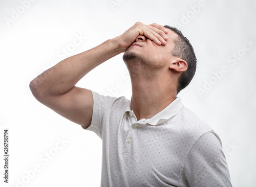 Man covering his face with his hand on white