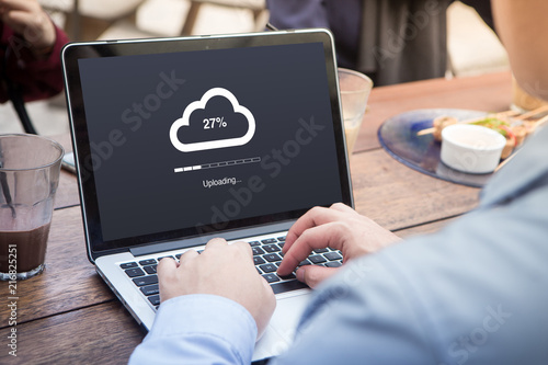 Businessman doing cloud uploading using laptop / computer concept at the outdoor cafe