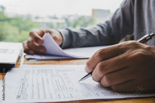 Closeup of man hand filling income tax forms