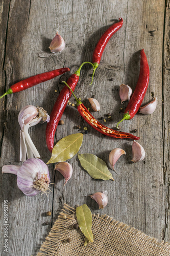 Świeże papryki chili, pieprz i czosnek na drewnianym tle