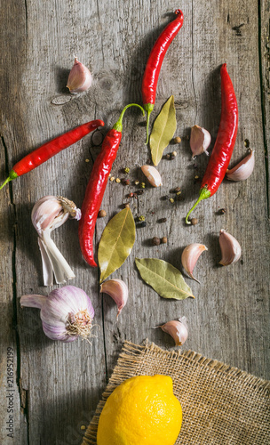 Świeże papryki chili, pieprz i czosnek na drewnianym tle