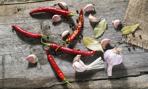 Świeże papryki chili, pieprz i czosnek na drewnianym tle