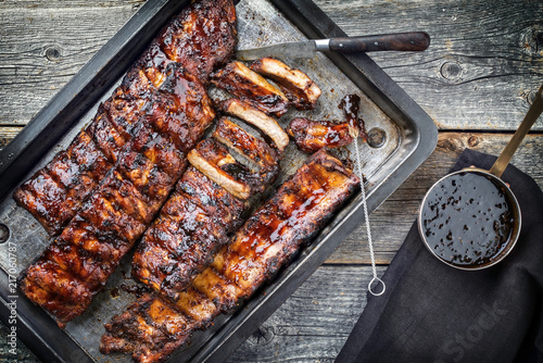 Barbecue spare ribs St Louis cut with hot honey chili marinade as top view in a rustic skillet