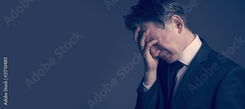 Frustrated and stressed businessman feeling depressed after fail (bankruptcy, debt, poverty and stress concept)