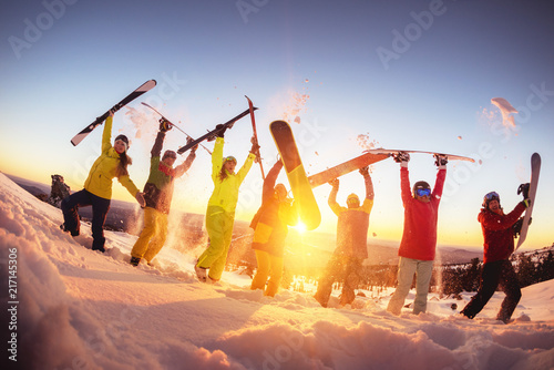 Happy friends at ski resort having fun sunset