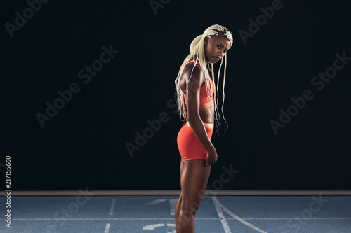 Female athlete standing on a running track