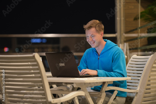 Happy Man Using Laptop Computer Outdoors At Night