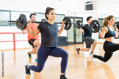 Weightlifter Lifting Barbell While Doing Lunges With Friends