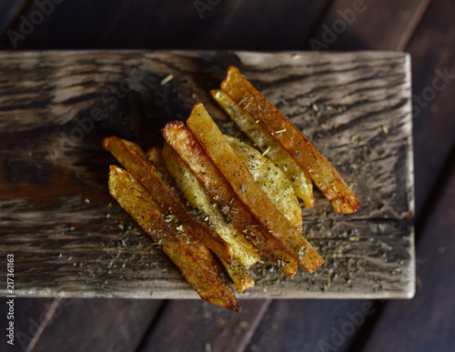 French fries with spices on wooden table